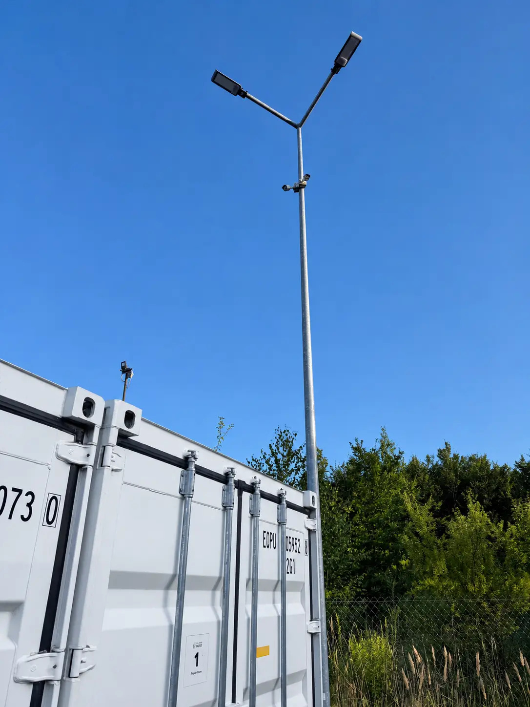 Lampy i kamery monitoringu na placu z kontenerami